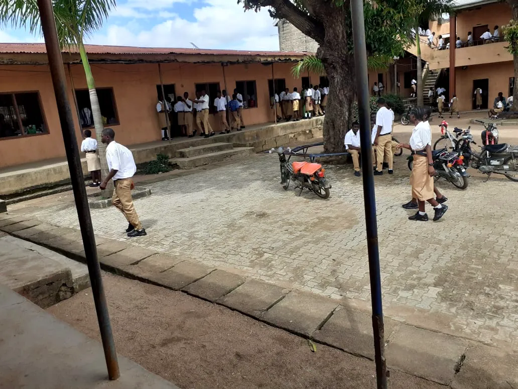 Students gathered by the older classroom block